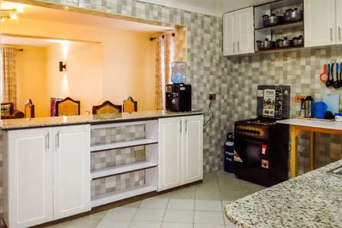 a kitchen with white cabinets and a counter top at Taliah Homestays in Nanyuki