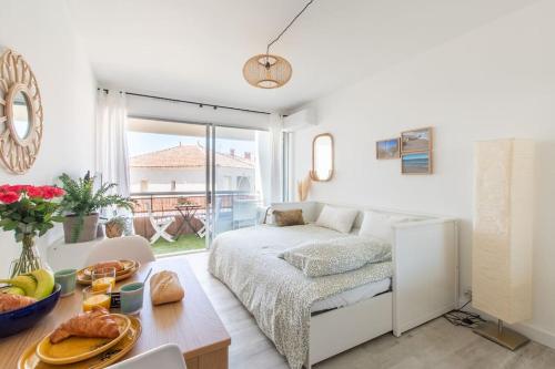 een slaapkamer met een bed en een tafel met eten erop bij Les flots turquoise * Climatisation * Plage * Mer in Carnon-Plage