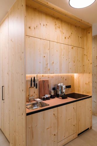 a kitchen with wooden walls and a counter with a sink at SCHILCHERLANDLEBEN - Hochgrail in Greisdorf