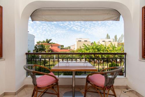 a table and chairs on a balcony with a view at STAR PARADISE Studios in Neos Marmaras