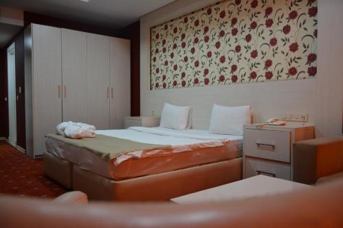 Ariva Hotel and Spa في باكو: غرفة نوم بسريرين ولوحة على الحائط