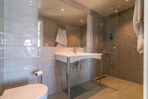 een badkamer met een wastafel, een toilet en een spiegel bij Bardufoss Hotell in Bardufoss