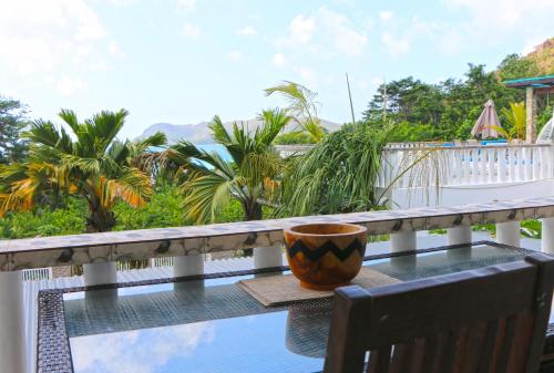 a coffee cup sitting on a table on a balcony at Ocean Blue Bay in Anse Volbert Village