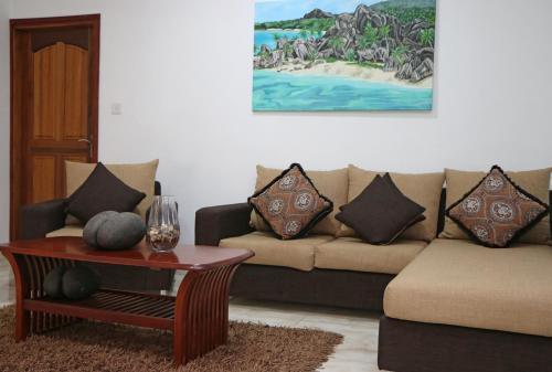 a living room with a couch and a table at Ocean Blue Bay in Anse Volbert Village