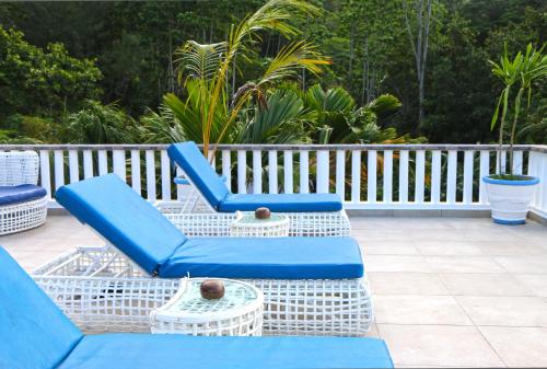 a group of blue chairs sitting on a patio at Ocean Blue Bay in Anse Volbert Village