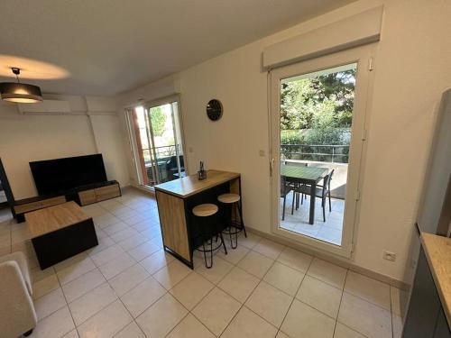 uma sala de estar com uma grande porta de vidro deslizante com uma mesa em Charmant Appartement Terrasse, Calme et Confort em Avignon