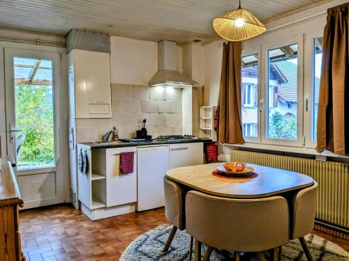 a kitchen with a table and a kitchen with a stove at Gîtes Le Verger in Taintrux
