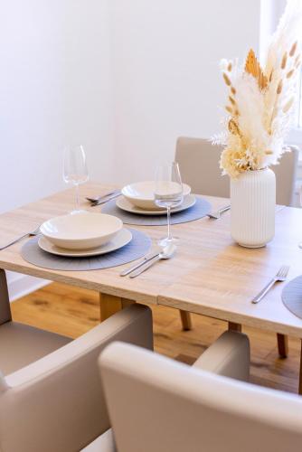a wooden table with plates and wine glasses on it at Hotel zur Börse in Hameln