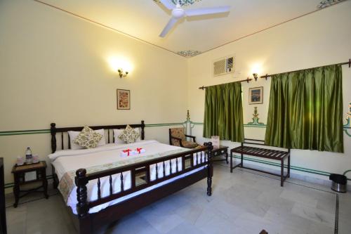 a bedroom with a bed and green curtains at Jaipur Vintage House in Jaipur
