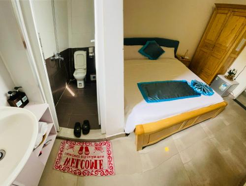 1 dormitorio con 1 cama y baño con lavamanos en SHARK HOSTEL en Hue