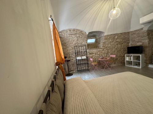 a bedroom with a bed and a stone wall at Giovinazzo Suite Spirito Santo in Giovinazzo