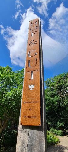 a sign on a wooden structure with trees in the background at Hof & Gut Jesteburg in Jesteburg