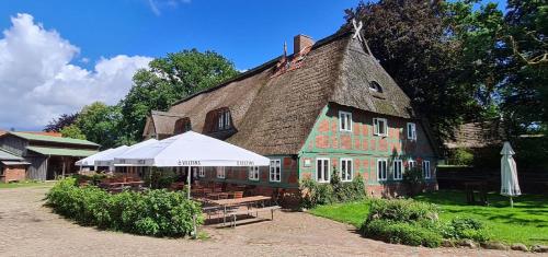 a building with a white umbrella in front of it at Hof & Gut Jesteburg in Jesteburg