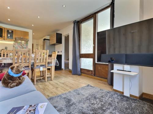 - un chien assis sur un canapé dans le salon dans l'établissement Appartement 6 personnes avec Parking Couvert - 1 chambre - 4 lits - Netflix & wifi haut débit, à Tignes