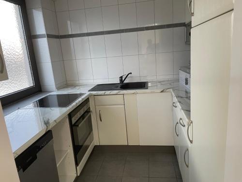 a small kitchen with a sink and a stove at Bataver in Neuss