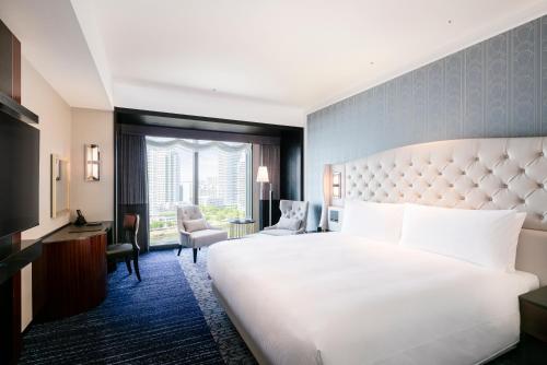 a hotel room with a large white bed and a window at Hilton Yokohama in Yokohama