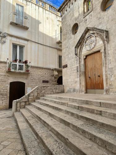 a stone building with stairs in front of a door at Giovinazzo Suite Spirito Santo in Giovinazzo