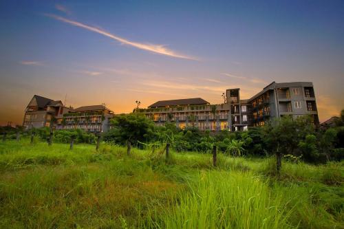 grupa budynków apartamentowych na polu trawy w obiekcie FRii Bali Echo Beach w mieście Canggu