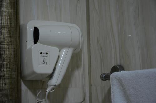 a white soap dispenser on the wall of a bathroom at Lara Hotel and Spa in Baku
