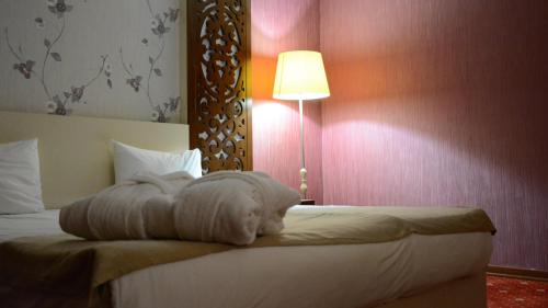 a hotel room with a bed with a towel on it at Lara Hotel and Spa in Baku
