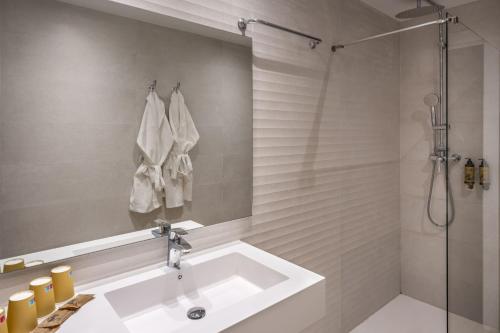 een witte badkamer met een wastafel en een douche bij Hotel Rovira in Cambrils