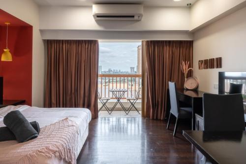 Cette chambre comprend un lit, un bureau et un balcon. dans l'établissement Sunway Lagoon Sweet Comfy Home for 1-5pax, à Petaling Jaya