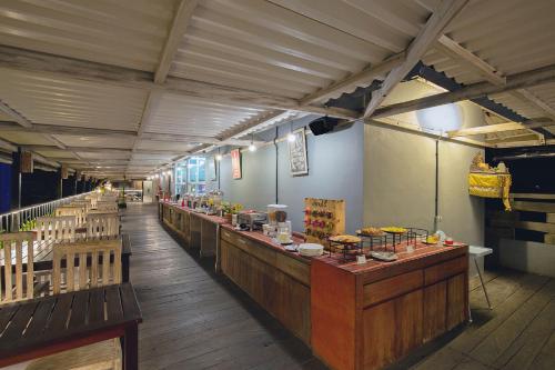 a restaurant with a long line of wooden counters at FRii Bali Echo Beach in Canggu