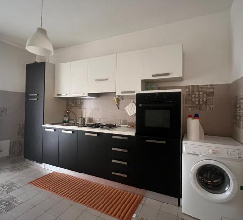 a kitchen with white cabinets and a washing machine at Malpighi 40 in Arezzo