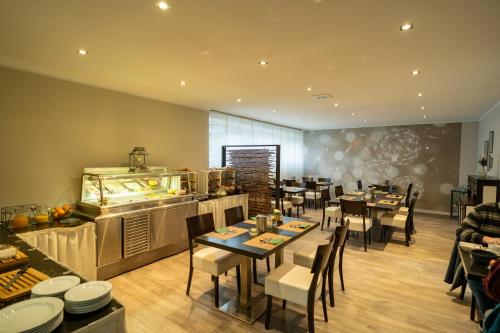a restaurant with tables and chairs and a kitchen at Waldhotel Surwold in Surwold