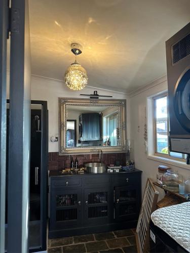 a kitchen with a sink and a mirror at Luxury 4 Bedroom Home with Pool & Games Room Bar in Bargara