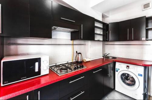 eine Küche mit schwarzen Schränken und einer roten Arbeitsplatte in der Unterkunft Cozy, comfortable apartments ismail !!! in Chişinău