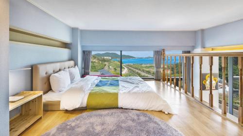 1 dormitorio con 1 cama grande y balcón en Paran Pension en Yeosu