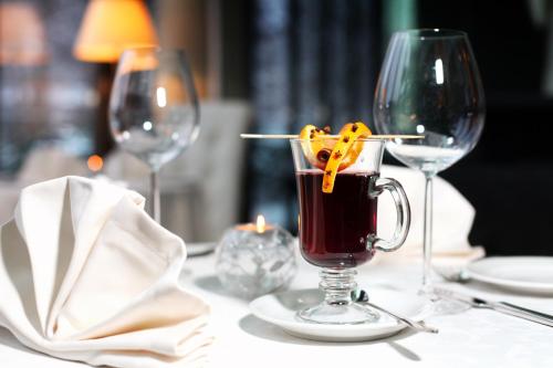 a table with two wine glasses and a drink at Rixwell Elefant Hotel in Rīga