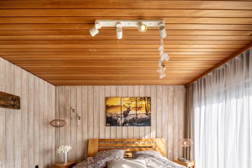 ヴァルデックにあるFerienhaus Auszeyt für Vierの木製の天井とベッド付きのベッドルーム1室