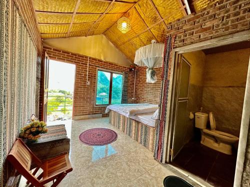 um quarto com um quarto com uma cama e uma janela em Du Gia Cozy Homestay & Tours em Làng Cac
