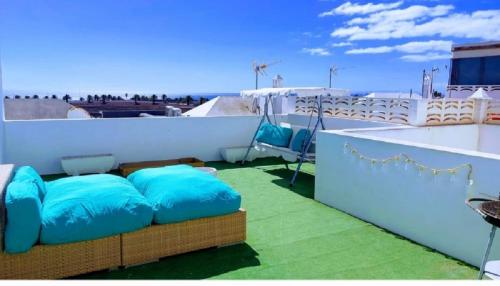 een balkon met blauwe kussens op een dak bij Mi isla bonita in Arrecife