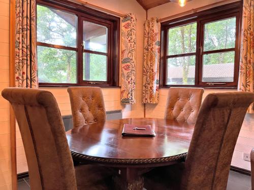 卡馬森的住宿－Woodland Lodge’s St Clears，一间带木桌和椅子的用餐室