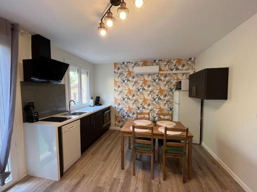 uma cozinha com mesa e cadeiras num quarto em Appartement « Le Mont Alba » em Perpignan