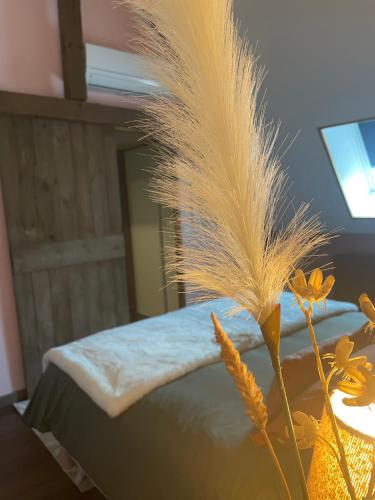 - une chambre avec un lit doté d'une table et d'une couette en plumes dans l'établissement Grande chambre confortable, à Saint-Amand-les-Eaux