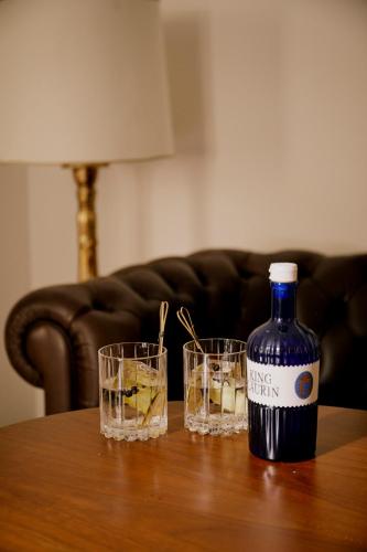 a bottle of wine and two glasses on a table at Parkhotel Laurin in Bolzano
