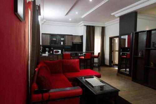 ein Wohnzimmer mit einem roten Sofa und einem Tisch in der Unterkunft Mosaly Residence Caboma in Cotonou