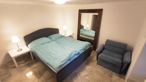 een slaapkamer met een bed, een stoel en een spiegel bij Chatka Petras in PalÃ¡rikovo