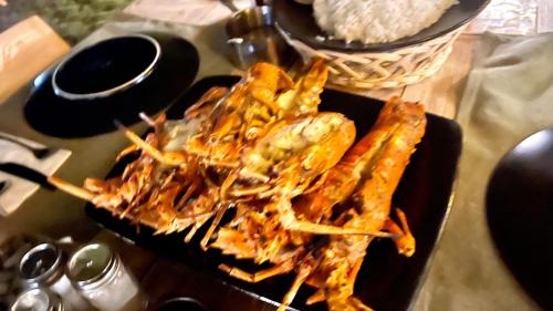 a plate of food on a table with rice at Lobster Bay Lombok in Awang
