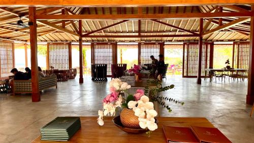 a lobby with a table with flowers on it at Lobster Bay Lombok in Awang
