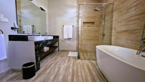 La salle de bains est pourvue d'une baignoire, d'un lavabo et d'une douche. dans l'établissement Dream of Zanzibar Resort & Spa - Premium All Inclusive, à Uroa