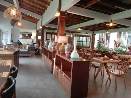 a restaurant with tables and chairs and vases on display at Santai Toraja in Rantepao