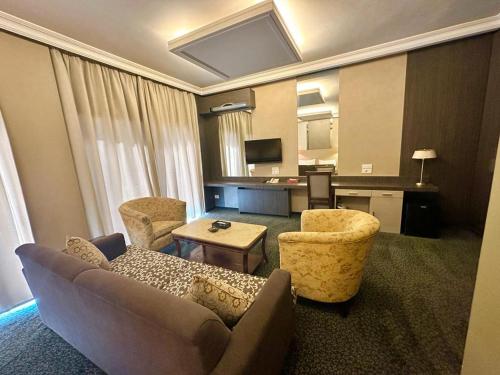 a living room with a couch and chairs in a hotel room at Padova Hotel in Beirut