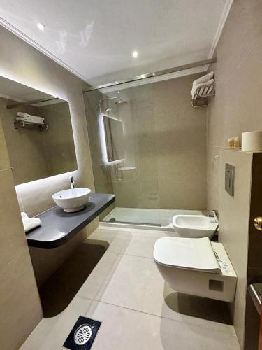 a bathroom with a toilet and a sink and a shower at Padova Hotel in Beirut