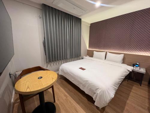 Tempat tidur dalam kamar di Geoje Highend Hotel