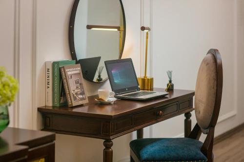 a laptop computer sitting on a wooden desk with a mirror at Gloud Hotel in Hanoi